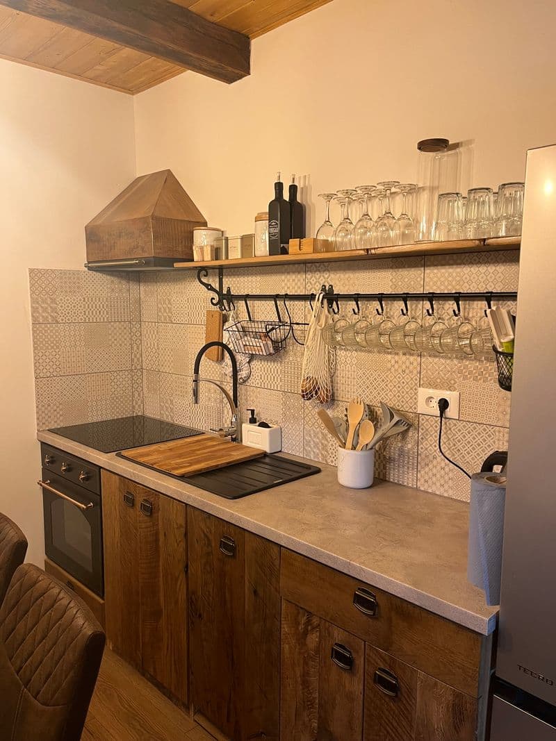 Kitchen detail with solid wood cabinetry, hob and hanging glassware