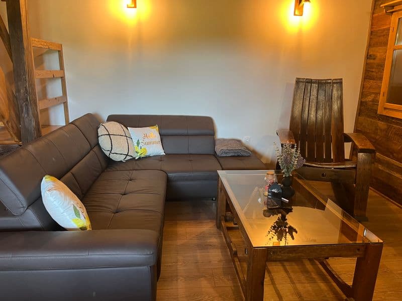 Living area with leather sofa, glass coffee table and wall sconces