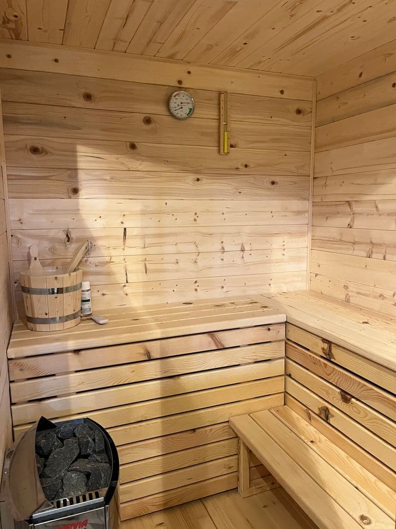 Interior of the Finnish sauna with tiered wooden benches and a bucket